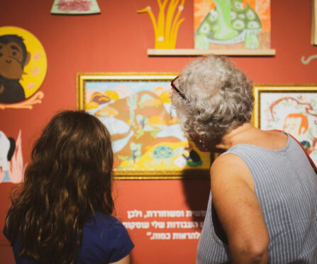 ארכיון פרוייקטים אישה וילדה מתבוננות בתמונה התלויה בתערוכה